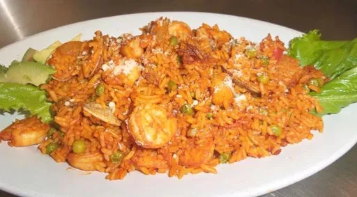 Close-up: Vibrant seafood rice with shrimp, clams, cheese, and avocado.