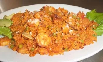 Shrimp and rice dish with peas, cheese, avocado, and lettuce.