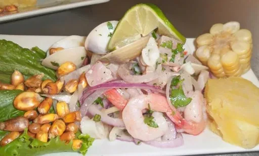 Colorful ceviche with shrimp, red onion, lime, corn, and sweet potato.