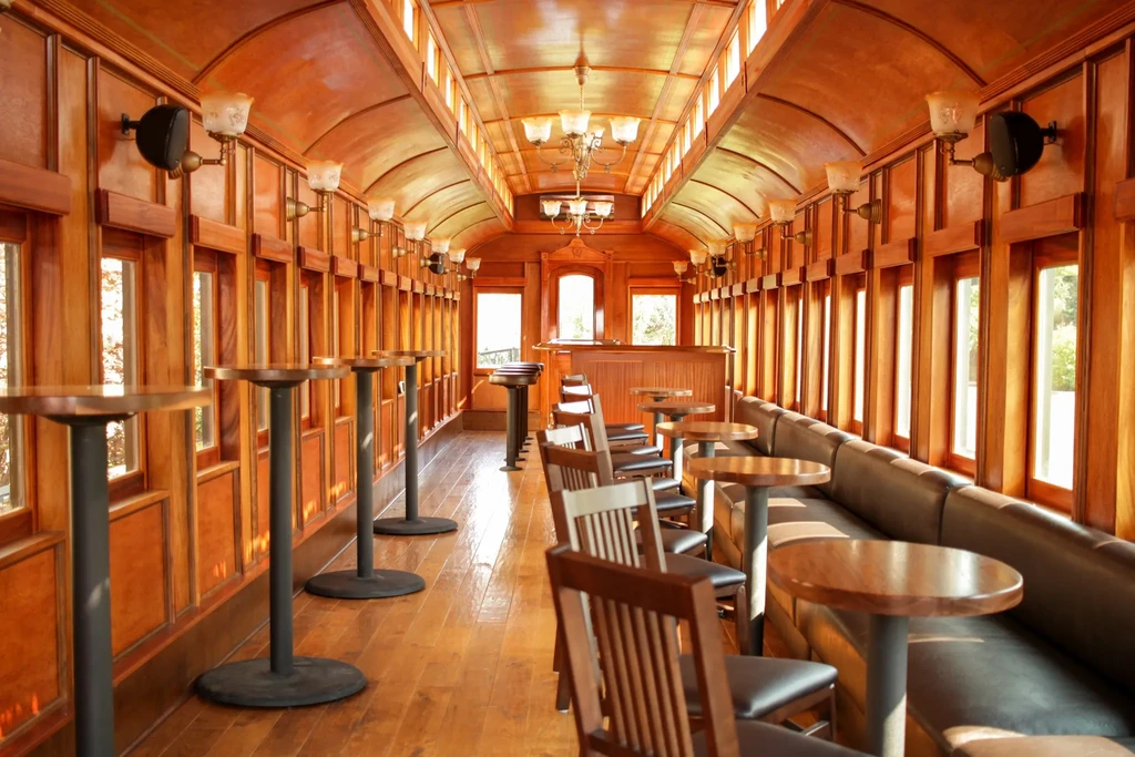 Warmly lit, wood-paneled restaurant interior with an arched ceiling and seating.