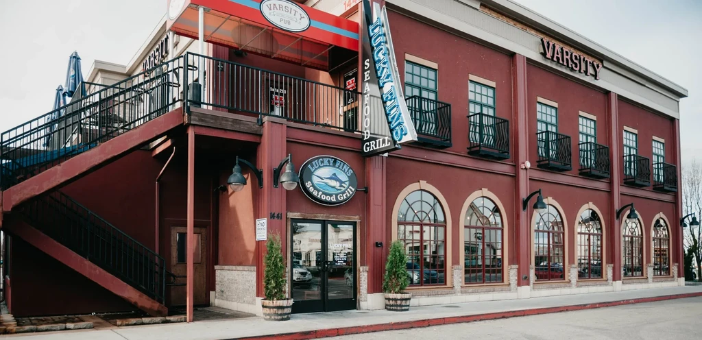 Two-story commercial building with Lucky Fins Seafood Grill and Varsity Pub.