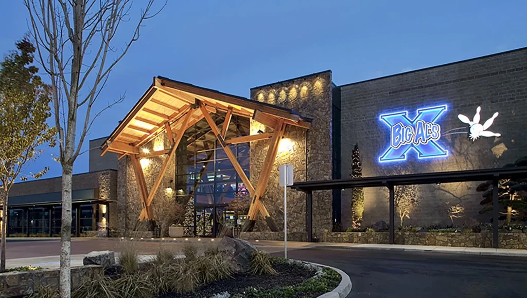 Modern stone and wood building at dusk with Big Al's bowling sign.