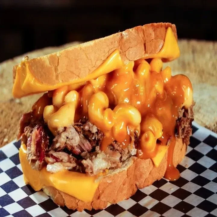 Close-up: Toasted sandwich with shredded meat, mac and cheese, melted cheese.
