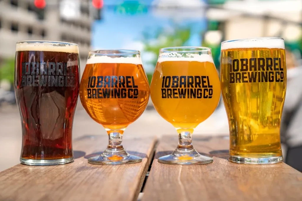Four '10 Barrel Brewing Co' beers: dark, two amber, and golden.
