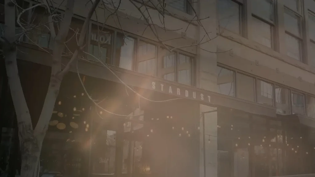 Hazy photo of STARDUST building exterior with glowing string lights.