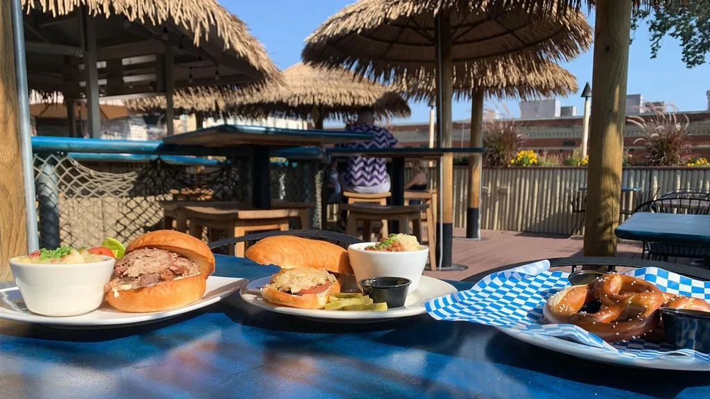 Three plates of food on a blue table at a sunny tropical restaurant.