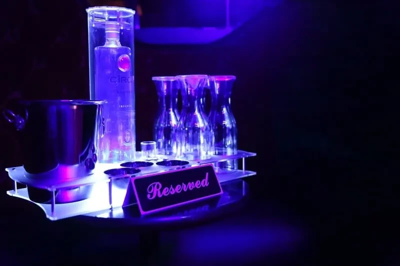 Purple and blue lit Ciroc bottle service with a Reserved sign.
