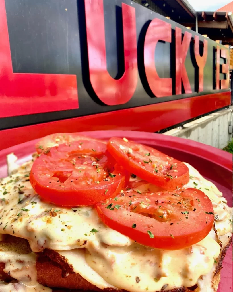 Savory open-faced sandwich with tomato, creamy sauce, and herbs.