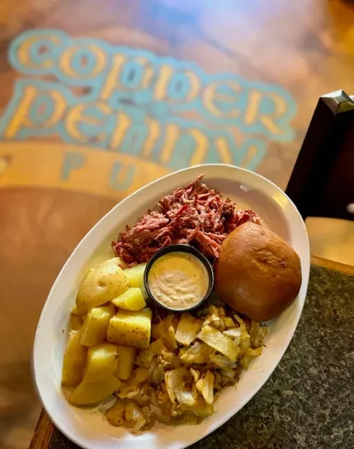 Meal at Copper Penny Pub: shredded meat, potatoes, cabbage, sauce, bun.