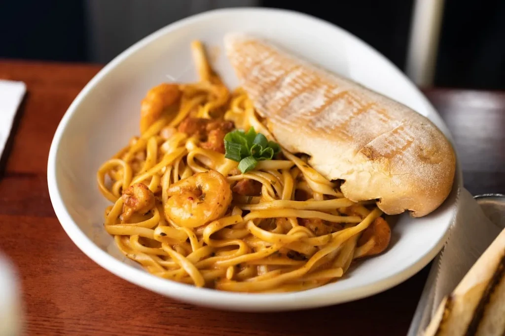 Linguine with shrimp, creamy orange sauce, herbs, breadstick.