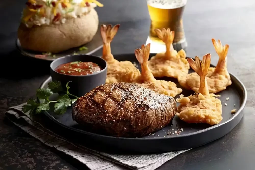 Grilled steak, fried shrimp, red sauce, baked potato, and beer.