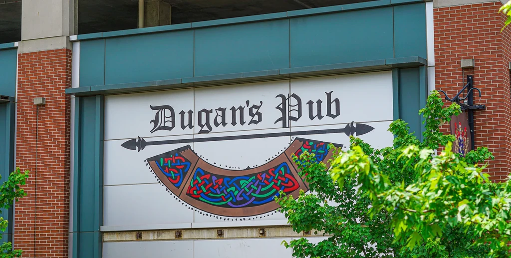 Dugan's Pub sign with colorful Celtic knots on a dark teal building.