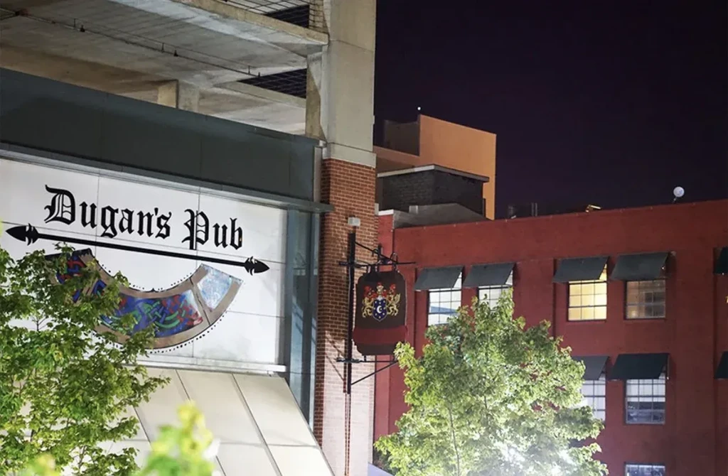 Night photo of Dugan's Pub illuminated signage and surrounding architecture.