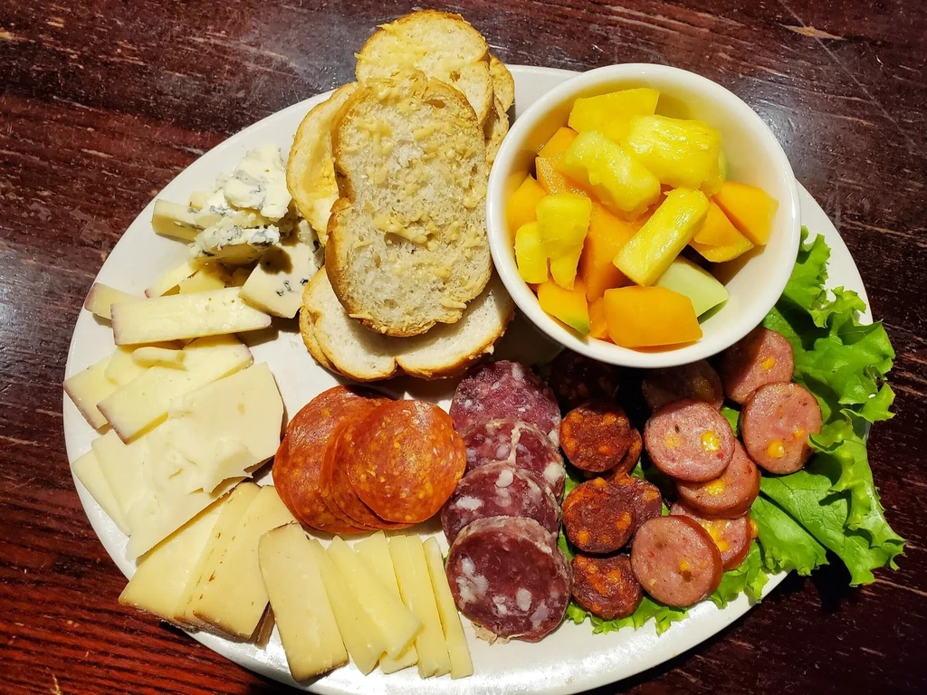 Generously portioned charcuterie board with cheeses, meats, fruit, and bread.