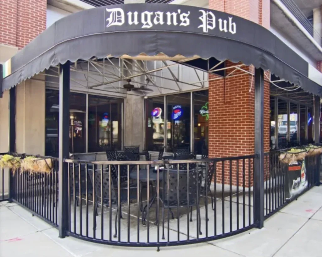 Dugan's Pub storefront: brick building, black awning, empty patio.