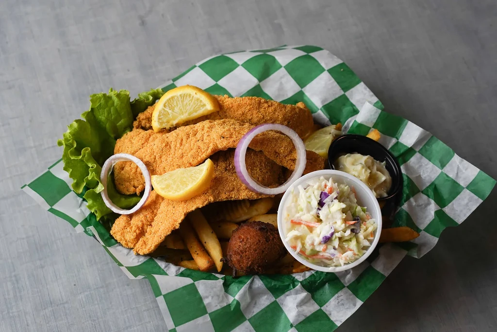 Three golden fried fish, fries, coleslaw, dipping sauce, hush puppy.