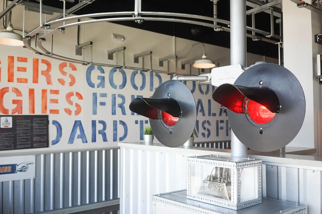 Two illuminated railroad crossing signals in a train-themed restaurant.