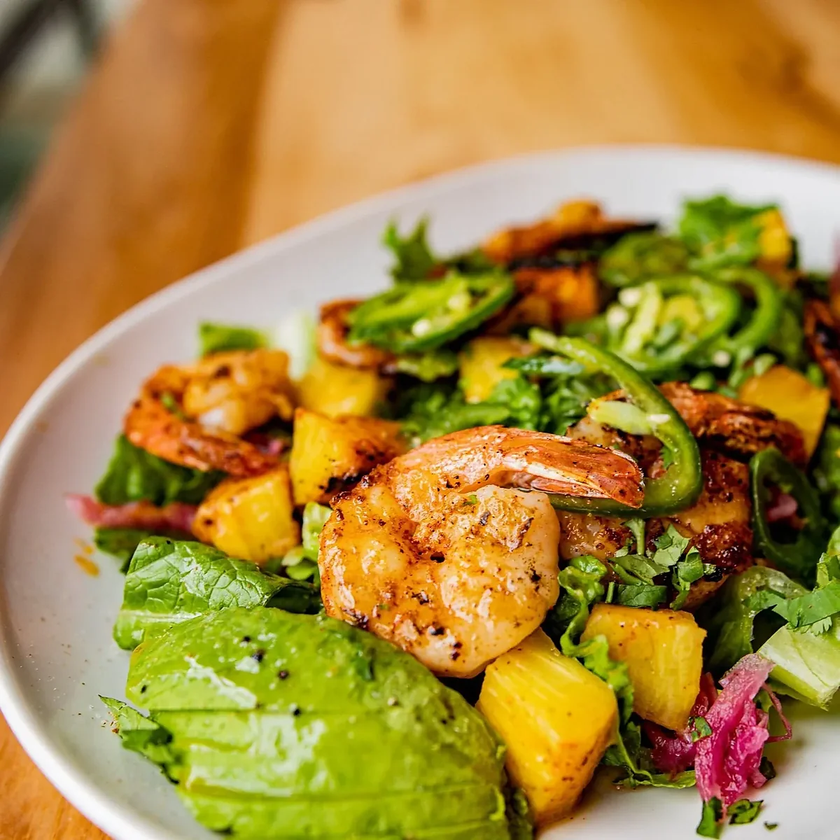 Grilled shrimp salad with pineapple, avocado, jalapeno and greens