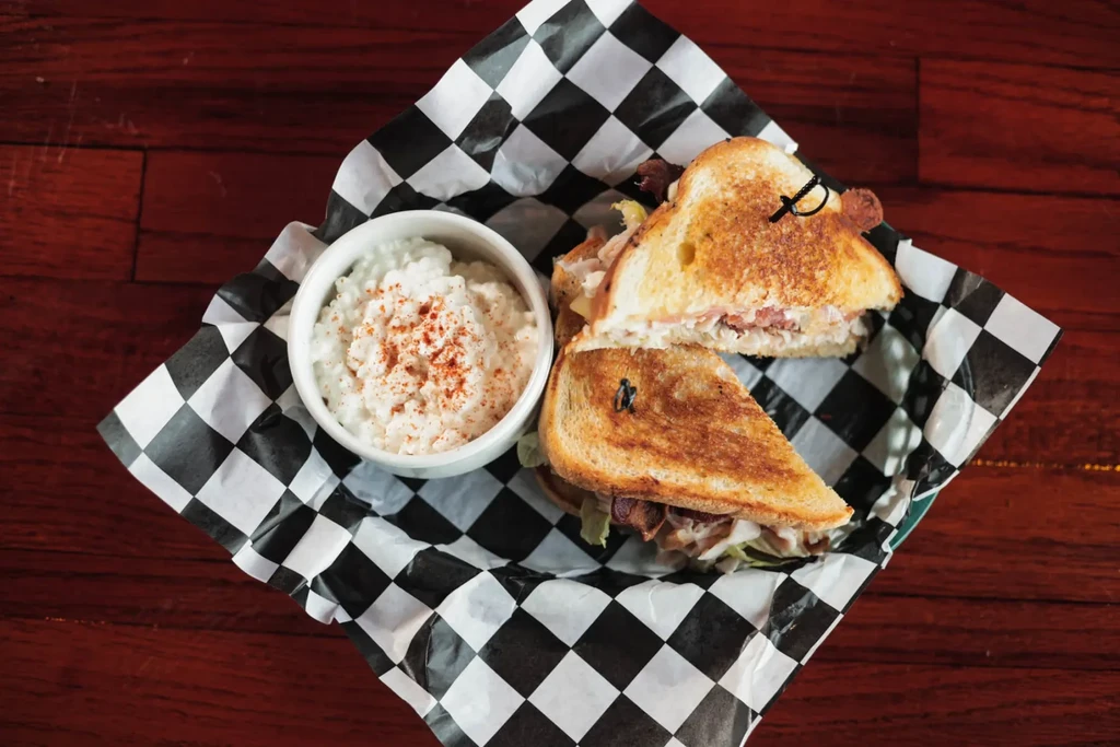 Toasted meat and lettuce sandwich, with cottage cheese side.