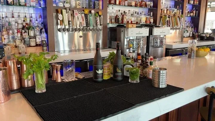 Modern bar setup with extensive liquor, beer taps, and cocktail equipment.