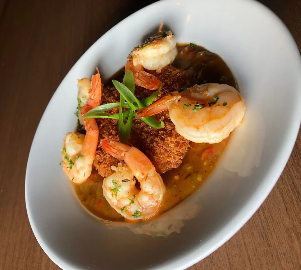Golden breaded fish and shrimp in reddish-brown sauce with green onion.
