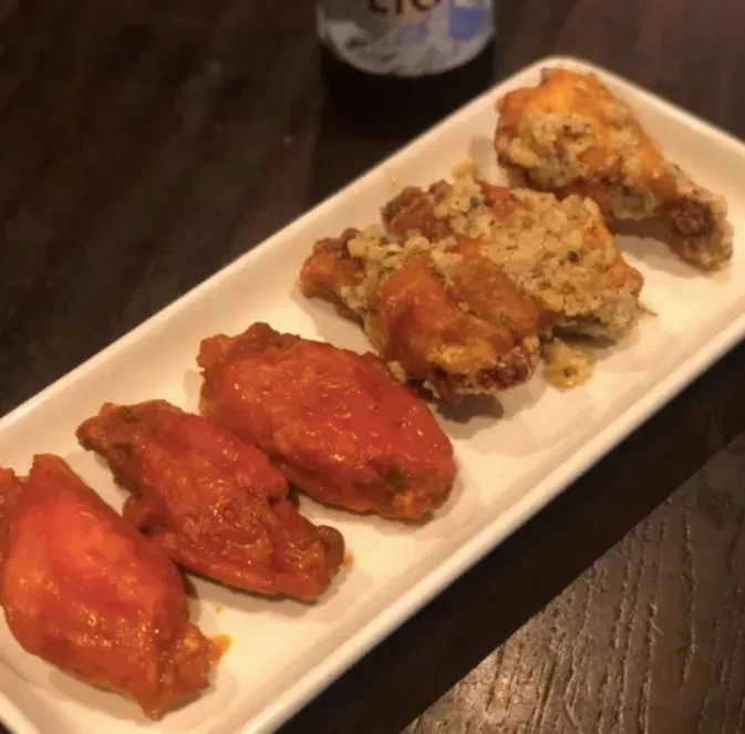 Platter of six chicken wings, three buffalo-style and three seasoned.