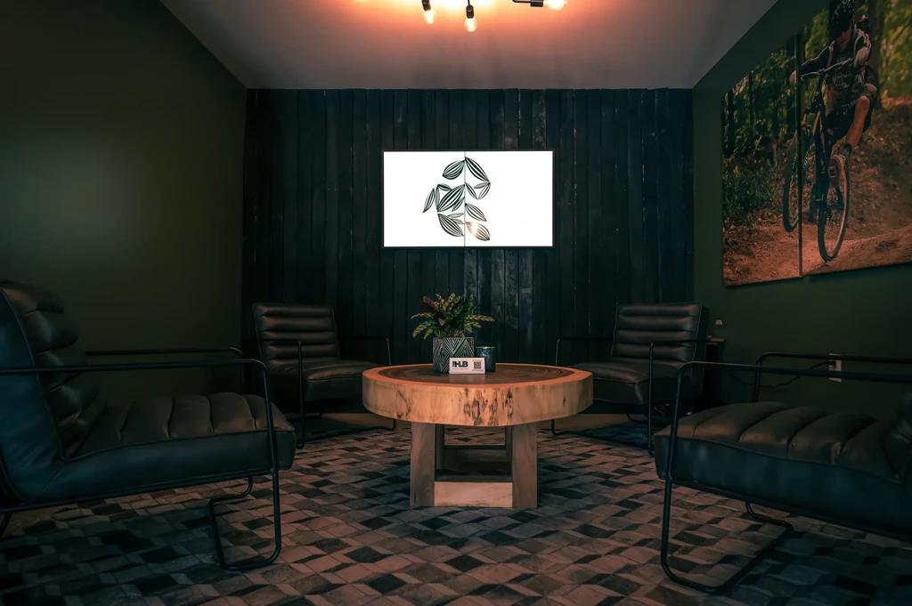 Dark green interior lounge with leather armchairs and a wood coffee table.