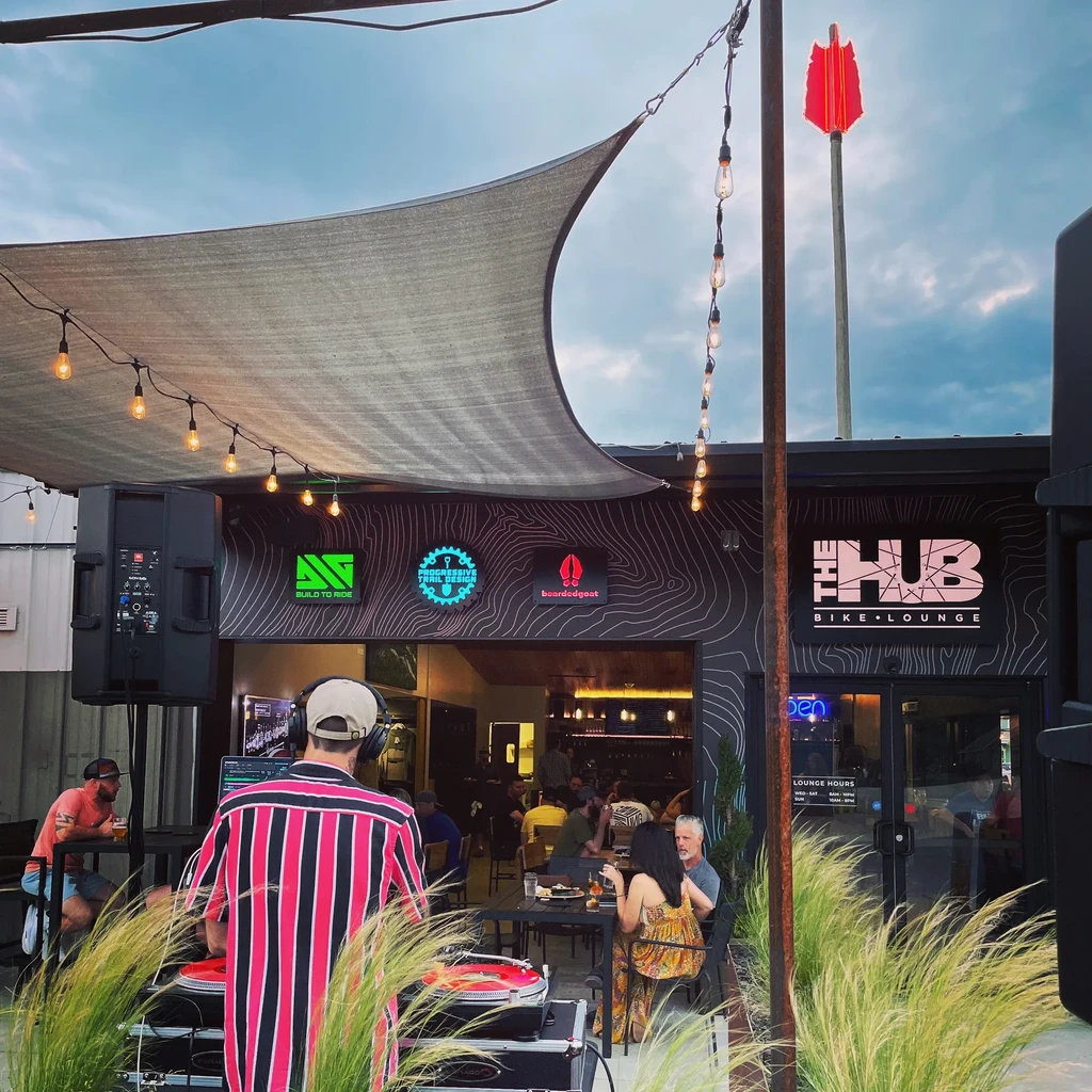 Outdoor patio at THE HUB BIKE LOUNGE with DJ and patrons.