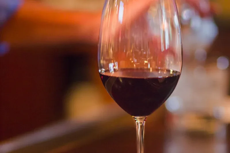 Close-up of a red wine glass with a blurred warm background.