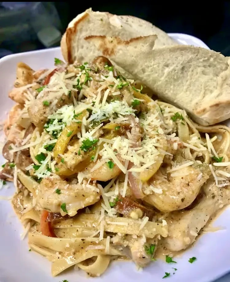 Creamy pasta with shrimp, chicken, peppers, Parmesan, parsley, and bread.