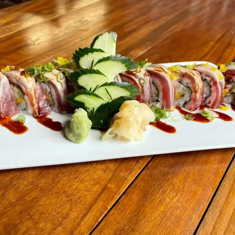 Plate of tuna sushi rolls with cucumber, wasabi, and pickled ginger.