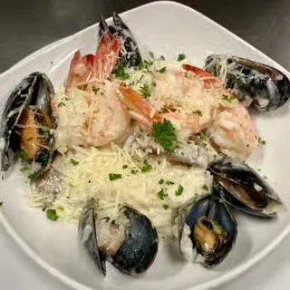 Creamy seafood dish with shrimp, mussels, and grated cheese.