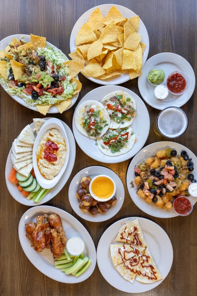 Overhead view of a wooden table filled with various appetizer-style foods.