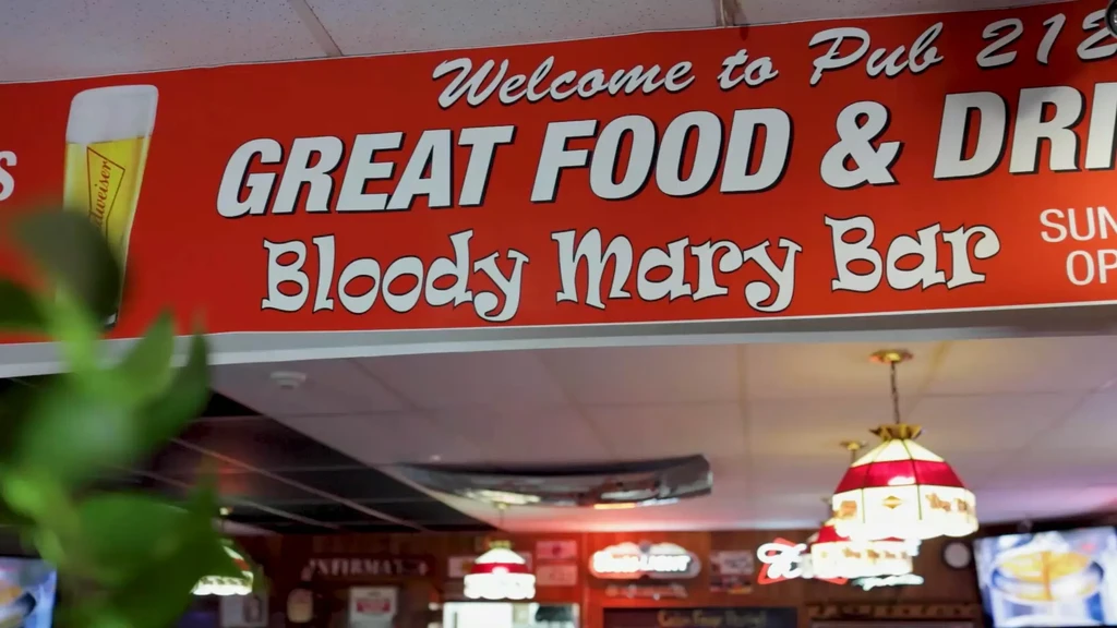 Large red 'Welcome to Pub 218' sign in a pub.