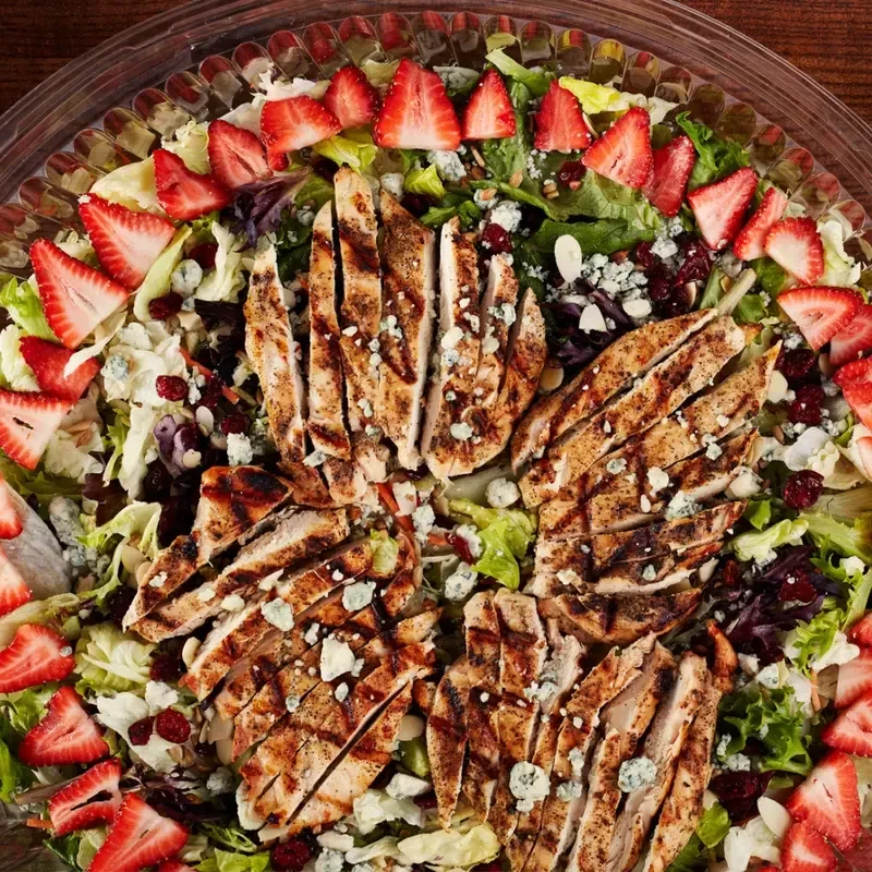 Large salad with grilled chicken, strawberries, blue cheese, cranberries, almonds.
