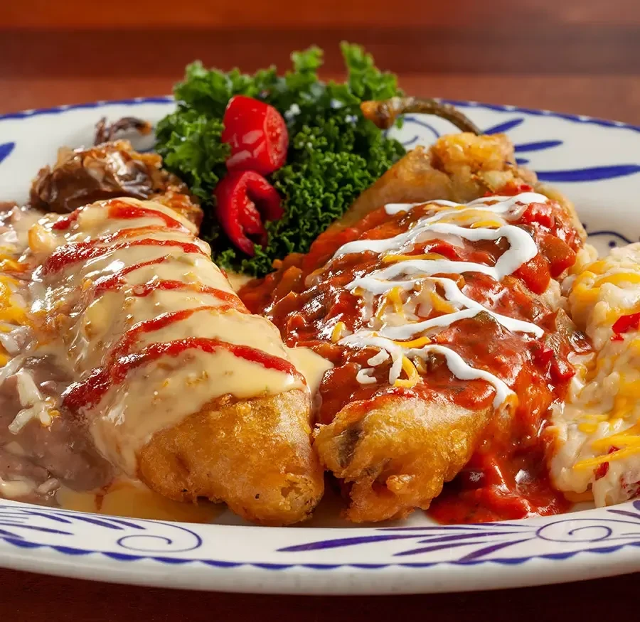 Close-up: Two vibrant sauced fried dishes with sides and garnish.