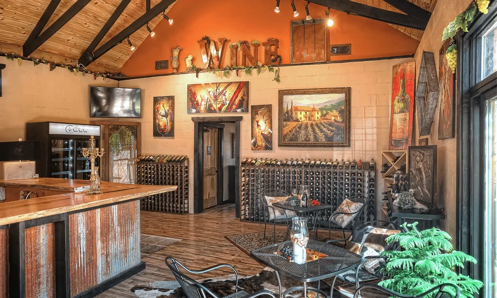 Cozy wine bar interior featuring a wooden bar, wine racks, and art.