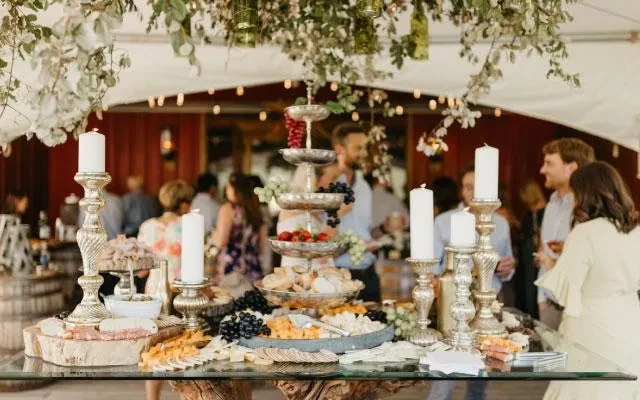 Elegant charcuterie buffet with cheeses, meats, and fruit at an event.