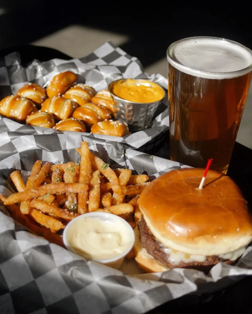 Pub meal: cheeseburger, seasoned fries, pretzel bites with cheese, and beer.