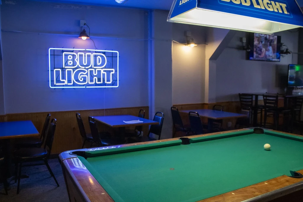 Empty bar with a green pool table and prominent Bud Light branding.