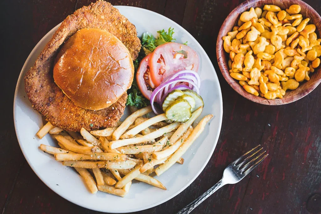 Fried cutlet sandwich, fries, salad, and goldfish crackers from above.