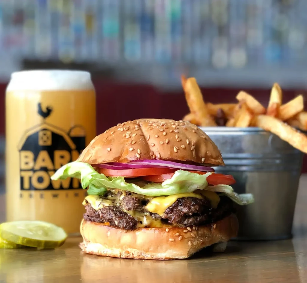 Hearty double cheeseburger, pickles, fries, and Barntown Brewing beer.