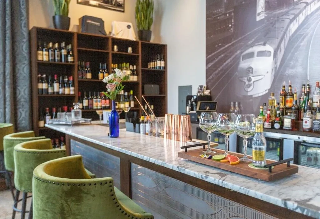 White marble bar with lime green stools and train mural background.