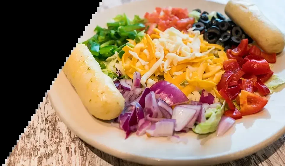 White plate with fresh, colorful deconstructed taco salad ingredients.