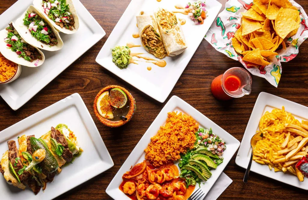 Overhead shot of a table laden with diverse Mexican food and drinks.