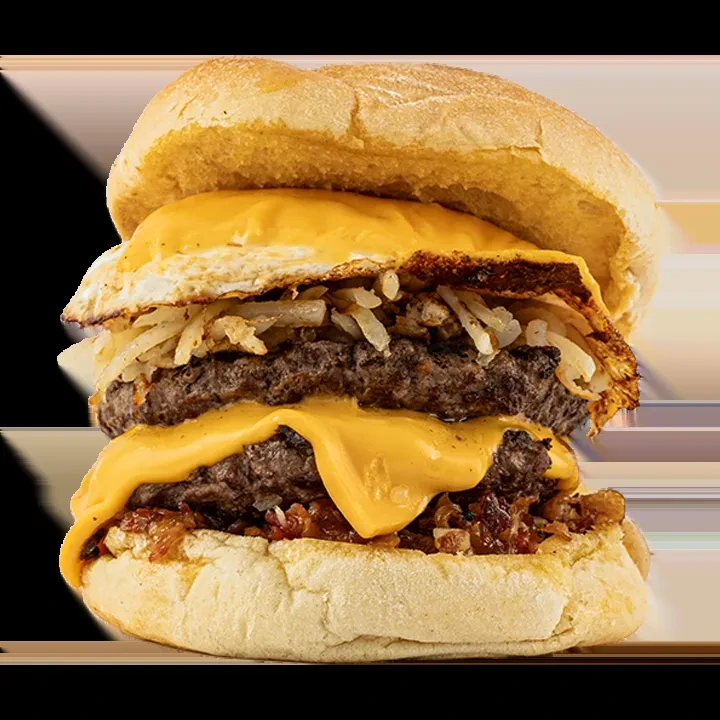 Multi-layered burger with fried egg, hash browns, two beef patties, melted cheese.