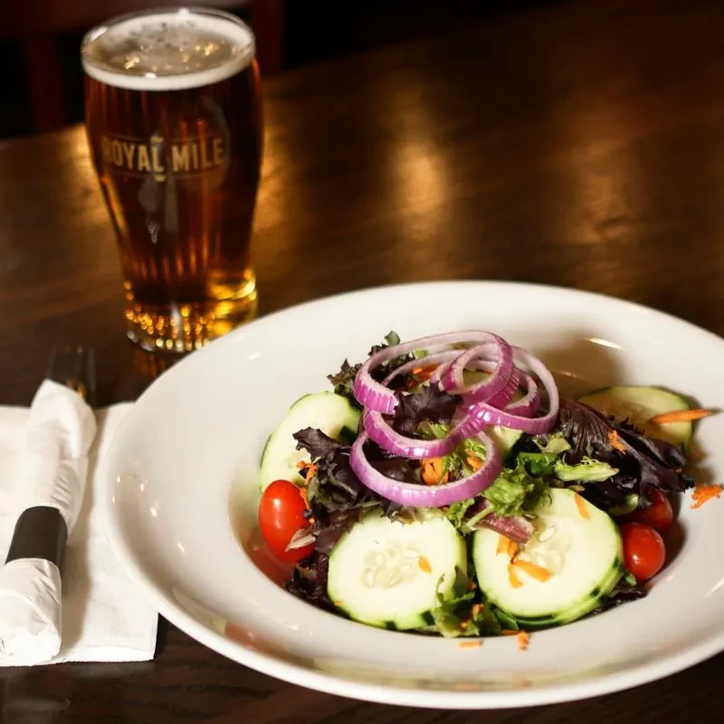 Fresh salad with mixed greens and a Royal Mile pilsner beer.