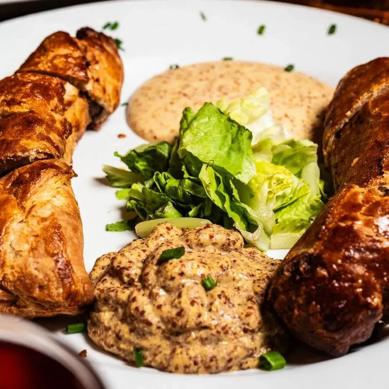 Flaky golden-brown pastry rolls, lettuce, whole-grain mustard, and creamy sauce.