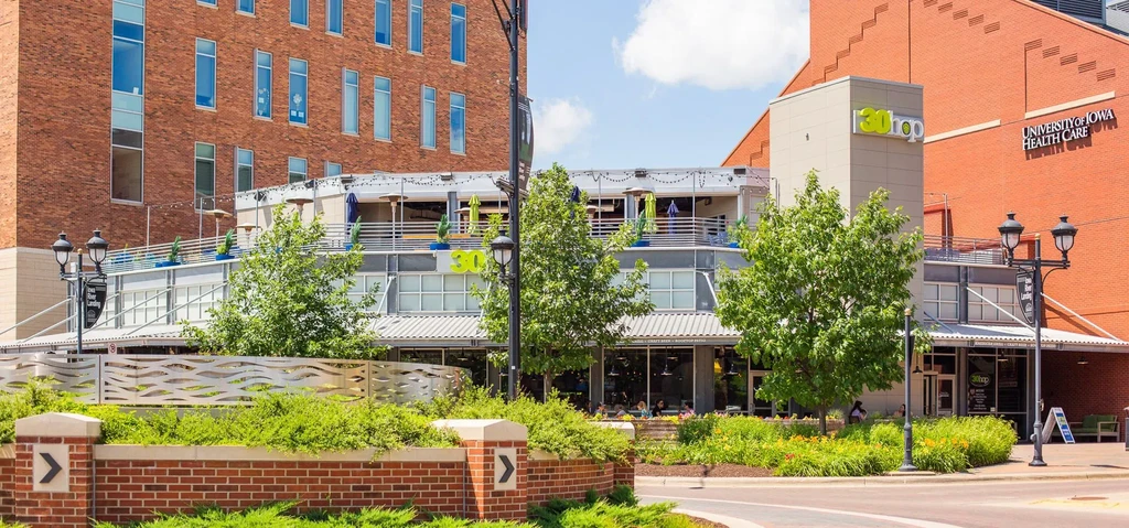 Modern urban building complex features 30hop restaurant with a rooftop patio.