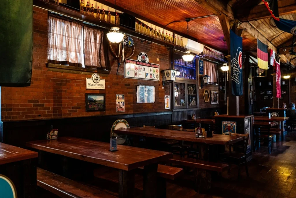 Rustic German restaurant interior with communal wooden tables and brick walls.